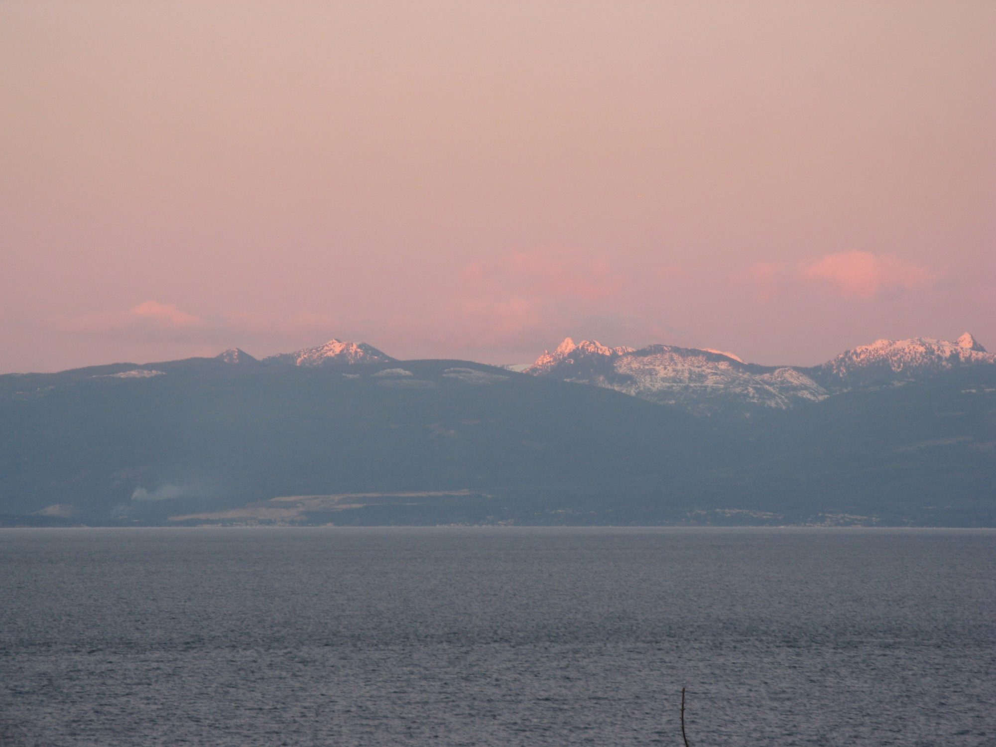Dusk over the Strait of Georgia in December, pink sky over the Coast Mountains, seen from the Nanaimo shore